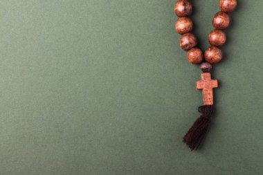 Ahşap tespih ve yeşil zemin üzerine çapraz.