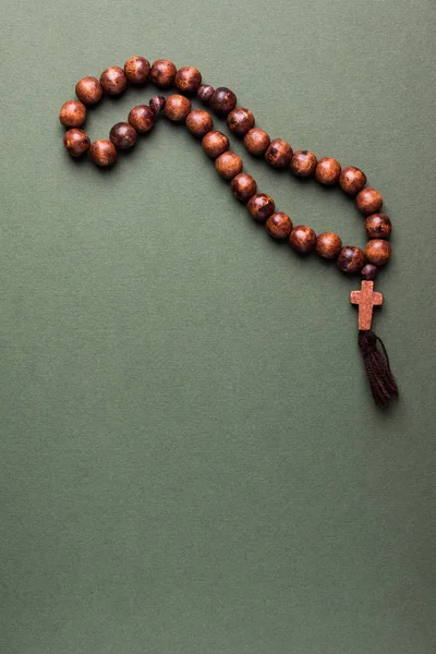 木製の数珠と緑の背景の上にクロス — ストック写真