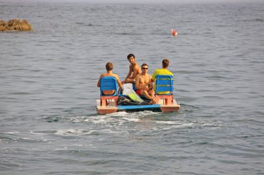 Tatildeki insanlar denizde katamarana biniyor. Ağustos 2009, Kırım, Ukrayna