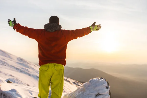 Silhouette of a man greets the sunrise in the mountains