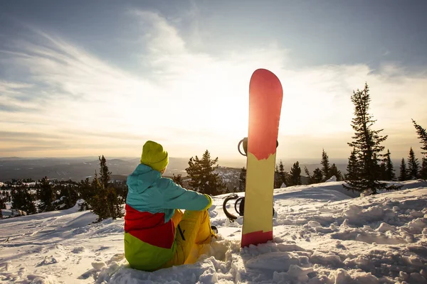 Snowboard oturan günbatımı şu anda sakin ol.