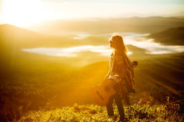 Genç kızla bir dağın zirvesinde gündoğumu bir gitar ile tanışır. — Stok fotoğraf