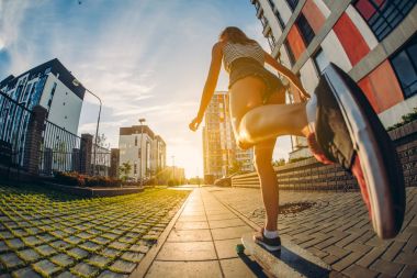 Şehir, genç kız kaykay hız. Güneş doğuyor. Bir yaşam tarzı. Longboard