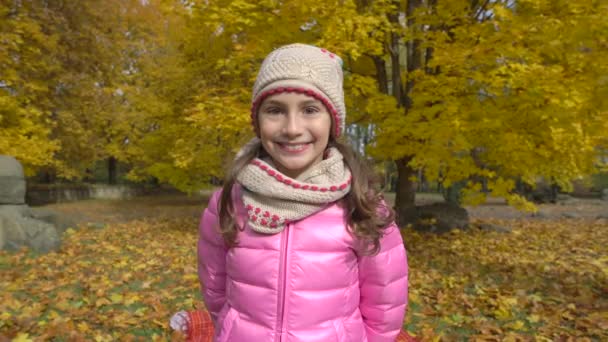 Κορίτσι φθινόπωρο πάρκο πίθηκος ντυμένοι με φωτεινά ρούχα. — Αρχείο Βίντεο