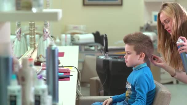 Parrucchiere rende il bambino ragazzo stile capelli al chiuso in salone . — Video Stock