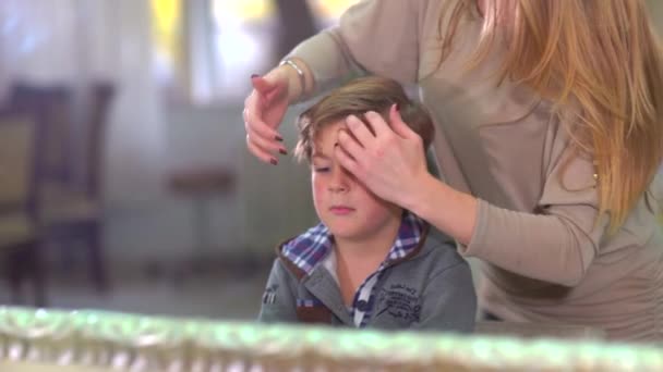 Cabeleireiro faz o estilo de cabelo menino criança dentro de casa no salão . — Vídeo de Stock