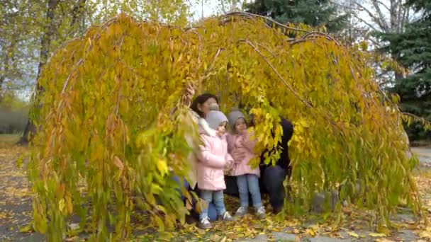 Família feliz andando no parque no outono. Pais e dois dias — Vídeo de Stock