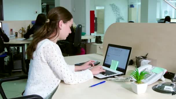 Jonge zakenvrouw werkt op kantoor op de computer. — Stockvideo