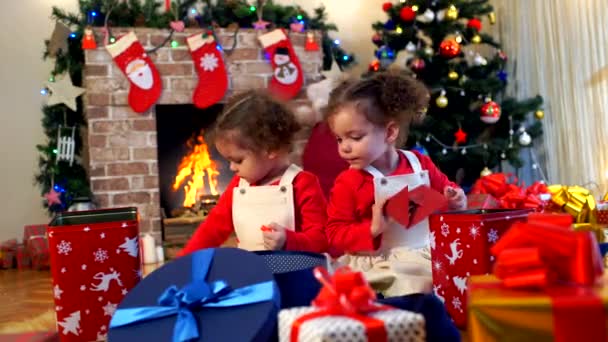 Dvě malé holčičky v čepice Santa Claus sedí na podlaze ŽÁ — Stock video