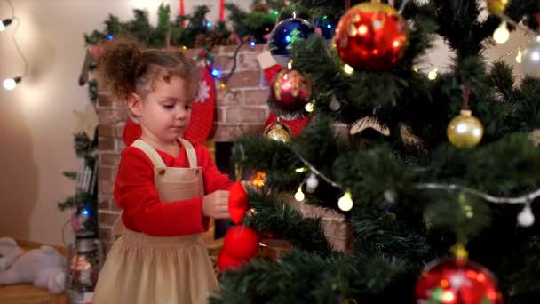 Kleine Kinder Schwester schmücken den Weihnachtsbaum Spielzeug, Geschenke in — Stockvideo