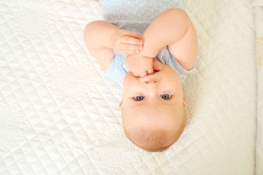 Beyaz bir arka plan üzerinde yalan gözlerine bakarken erkek bebek