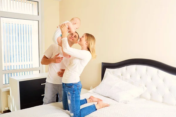 El concepto de familia feliz. Papá sostiene a su bebé cerca de la madre — Foto de Stock