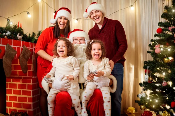 Gelukkige familie met de Kerstman lachen en glimlachen. — Stockfoto