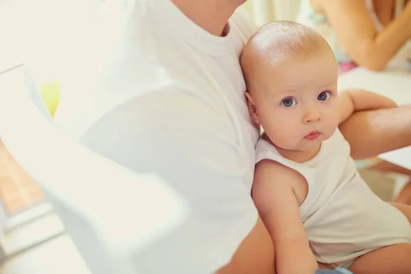 Niño bebé en brazos de su padre mirando a la cámara — Foto de Stock