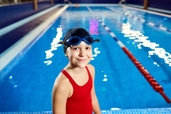 Menina nadadora criança em um maiô vermelho no fundo — Fotografia de Stock
