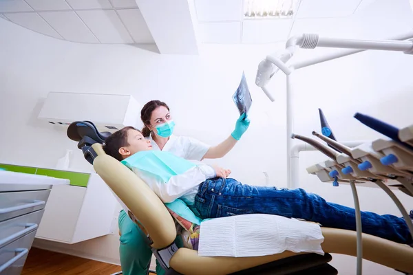 Doktor diş hekimi ve çocuğunu bir x-r izlerken ofisimizde — Stok fotoğraf