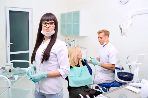 Dentiste femme dans des lunettes sur l'équipement de fond . — Photo