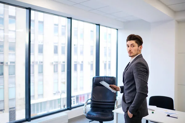 Homme d'affaires avec une tablette dans les mains du bureau sur le backgrou — Photo