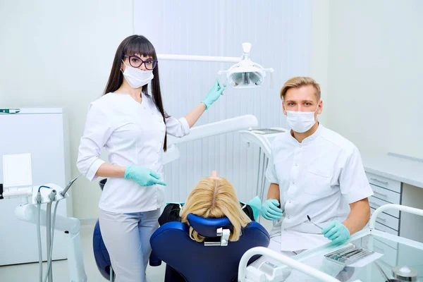 Le patient, le dentiste et l'assistant au cabinet d'une clinique dentaire — Photo