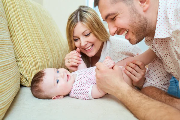 Baby with mom and dad smiling laughs in the room Stock Photo