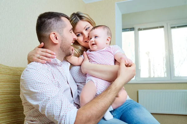 Bebé con mamá y papá sonriendo ríe en la habitación . — Foto de Stock