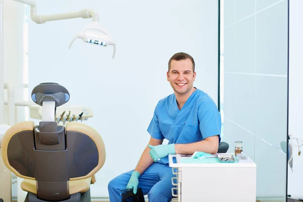 Dentista sonriente sentado en la oficina —  Fotos de Stock