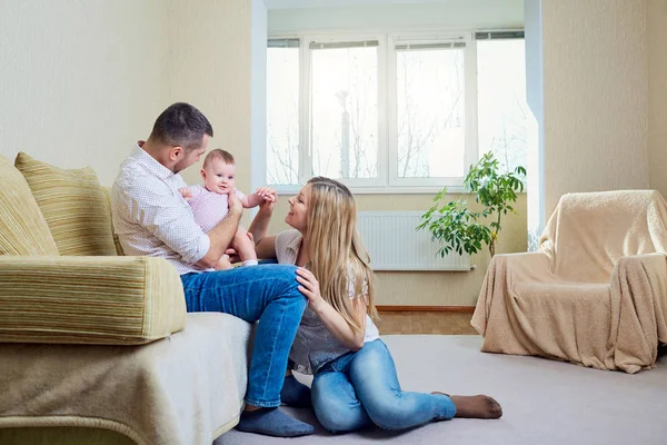 Söt baby leker med föräldrar i rummet — Stockfoto