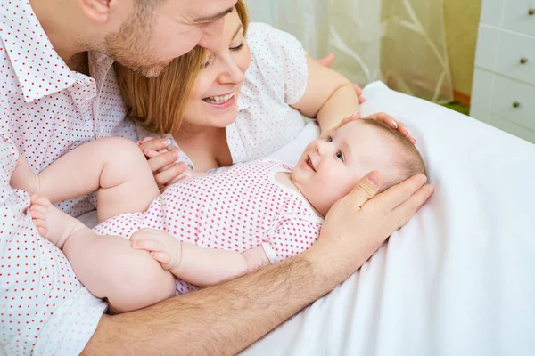 Bebé con sus padres feliz hogar en el sofá. Mamá y papá playi — Foto de Stock