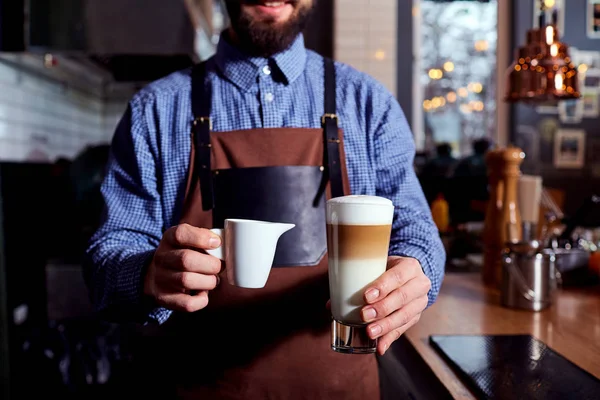 Cantinero barista con capuchino en la mano —  Fotos de Stock