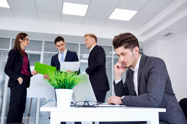 Empresário em sua mesa trabalhando em um laptop no fundo bu — Fotografia de Stock