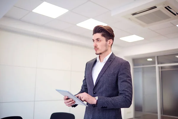 Homme d'affaires avec une tablette dans les mains du bureau sur le backgrou — Photo