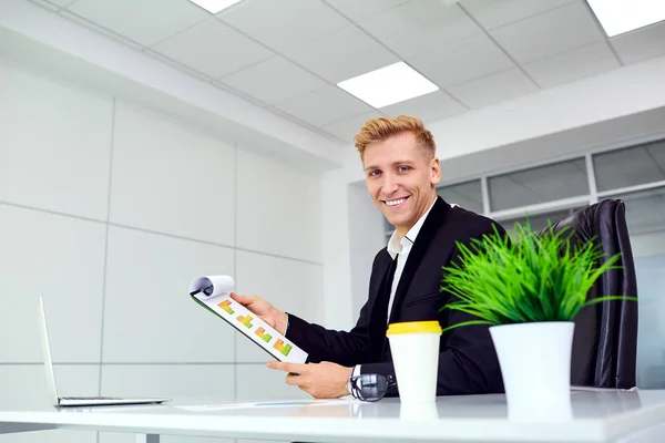 Homme d'affaires souriant blond pour un ordinateur portable à son bureau dans le bureau — Photo