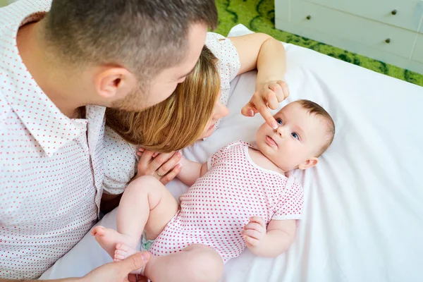 Bebé con su madre y su padre en la cama jugando juntos. Hap. — Foto de Stock