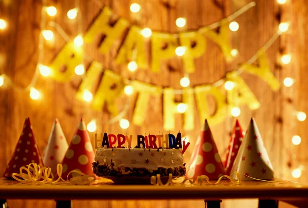 Feliz bolo de aniversário com velas no fundo de guirlandas um — Fotografia de Stock