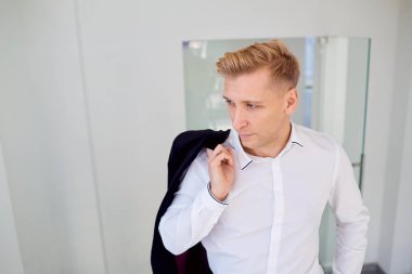 Bir ceket omzunun üzerinden ile Beyaz gömlekli adam sarışın