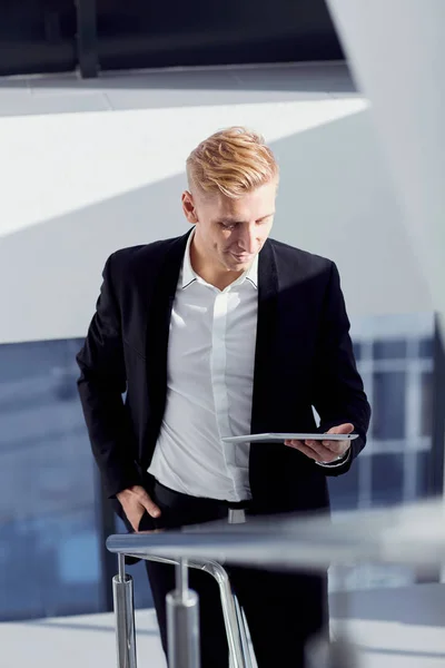 Un homme en costume avec une tablette à la main le bureau — Photo