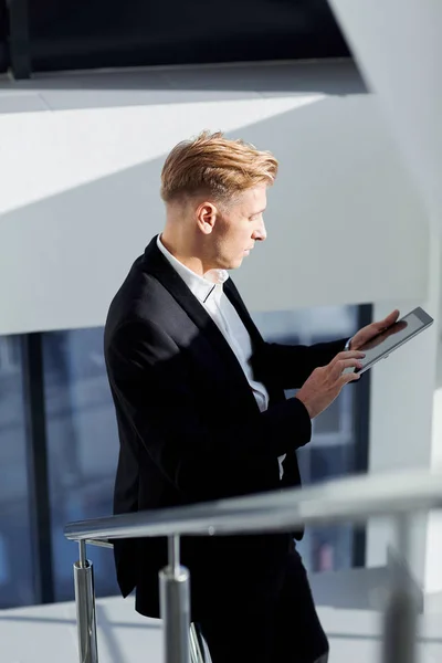 Un homme en costume avec une tablette à la main le bureau — Photo