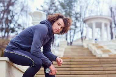 Bir şişe su parkta koşu sonra kıvırcık delikanlı