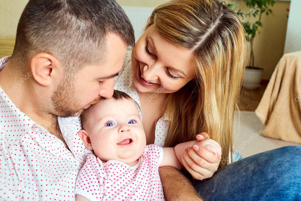 Una familia feliz. Mamá y papá con el bebé en la sala de — Fotos de