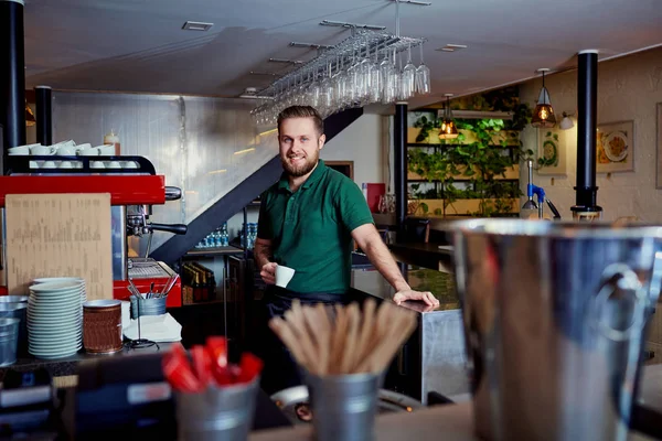 Barman barista con café en la mano detrás de la barra en la brea — Foto de Stock