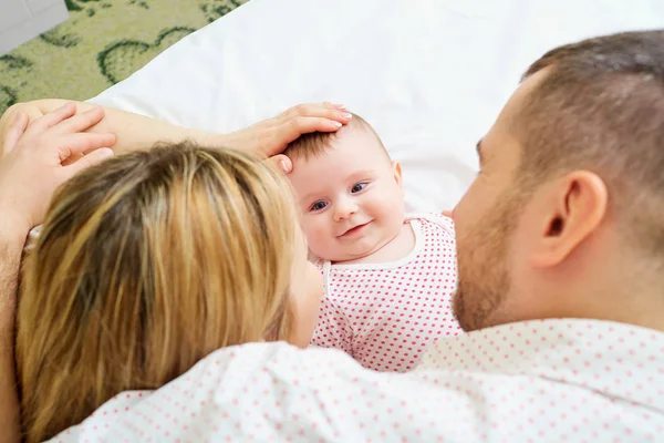 Familia feliz. Madre y padre están acostados en la cama con su — Foto de Stock