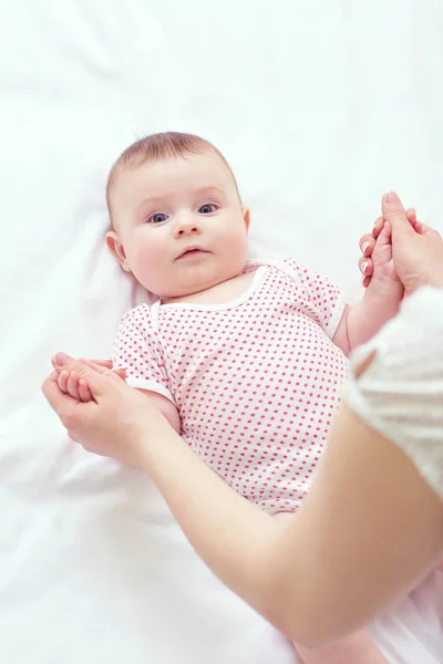 Baby child is holding his mother lying on bed — Stock Photo, Image