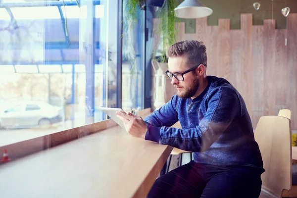 Tablet elinde serbest hipster adamla Cafe tarafından t çalışır.