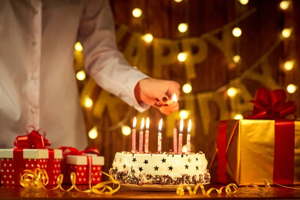 여자 손에 생일 케이크에 촛불 매치 라이트 — 스톡 사진