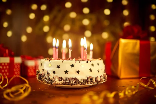 Torta di compleanno felice con candele sullo sfondo di ghirlande a — Foto Stock