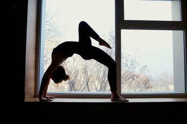 Kadın arka plan pencere köprüde Yoga yapıyor. Egzersiz