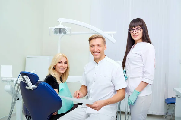 Une équipe de dentistes avec un client dans un cabinet dentaire — Photo