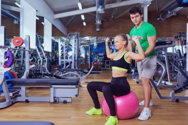 Kişisel antrenör ve egzersizleri yaparken dumbbells ile kız