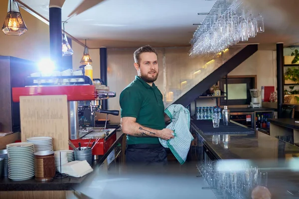 Cantinero, barista trabajando limpia el vaso con un paño en un descanso — Foto de Stock