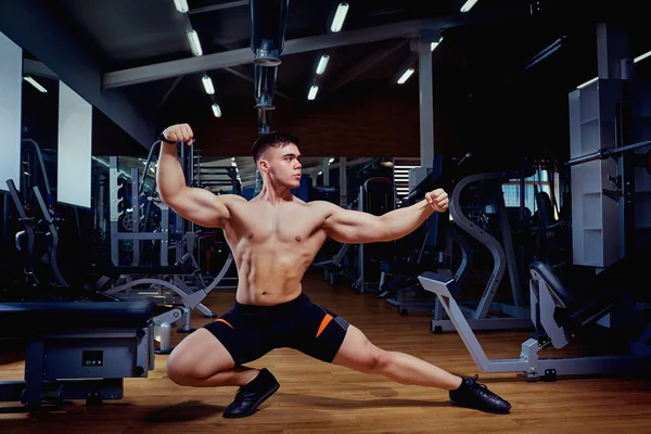 Sportsman athlete bodybuilder posing in the gym — Stock Photo, Image